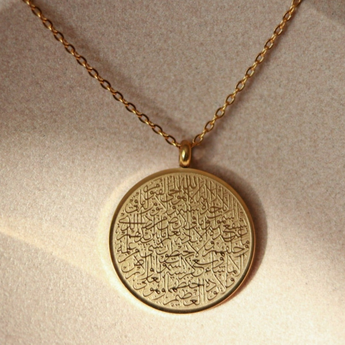 Goldene 18 Karat vergoldete Halskette mit rundem Anhänger auf dem in arabischer Schrift und feinster Kalligrafie Ayatul Kursi, der Thronvers eingraviert ist