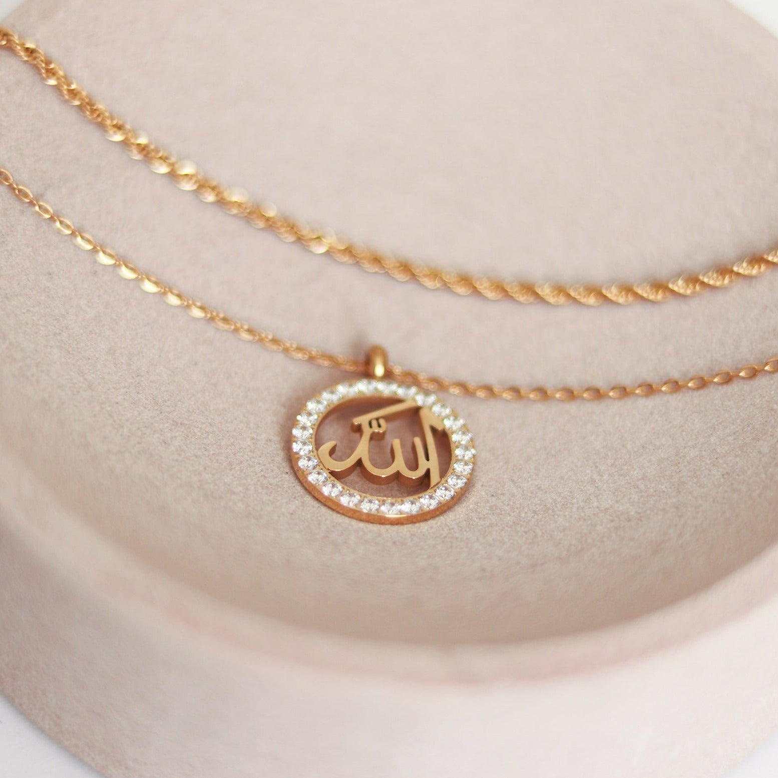 Halskette mit rundem Anhänger und der Aufschrift auf arabisch "Allah". Das Wort "Allah" ist mit funkelnden weißen Zirkoniakristallen umrandet